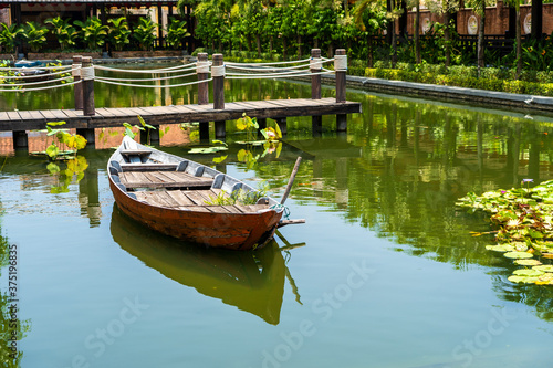 Wooden boat on the pond near the pier in a tropical garden in Danang  Vietnam