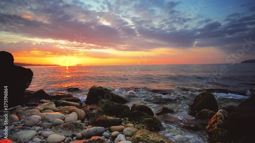 Sea sunrise over tropical island beach with rocky coastline
