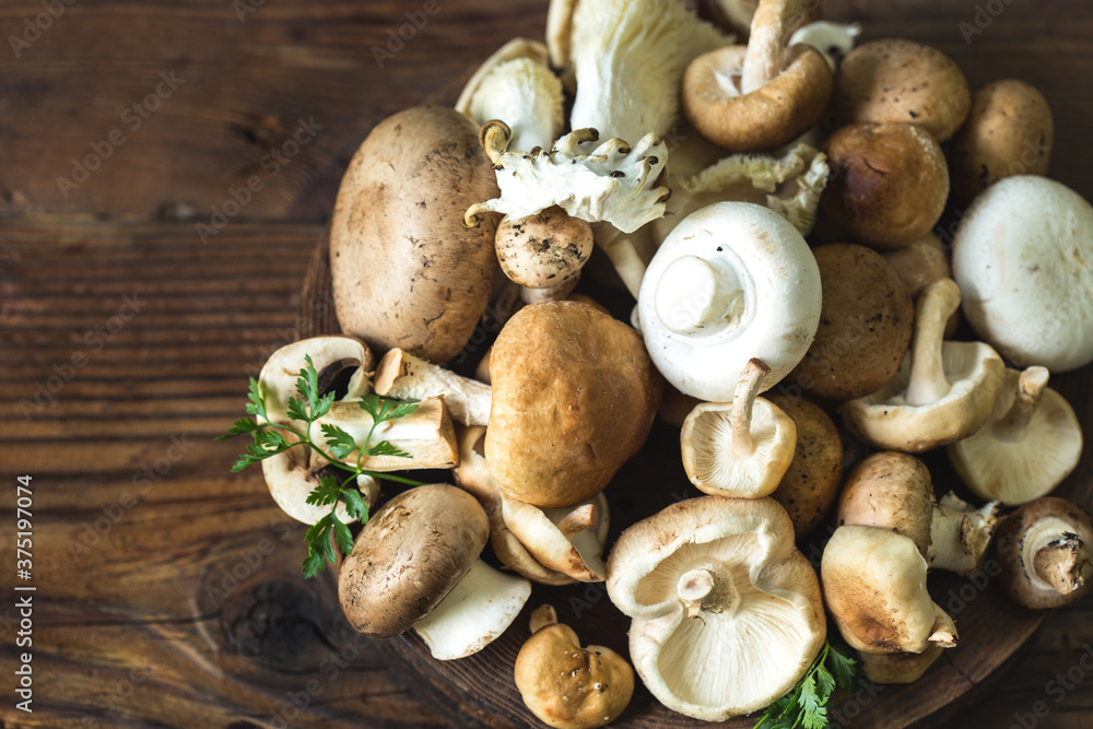 Different edible mushrooms on the wooden table