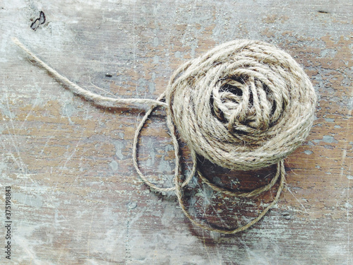 A spool of twine or yarn on a wooden table