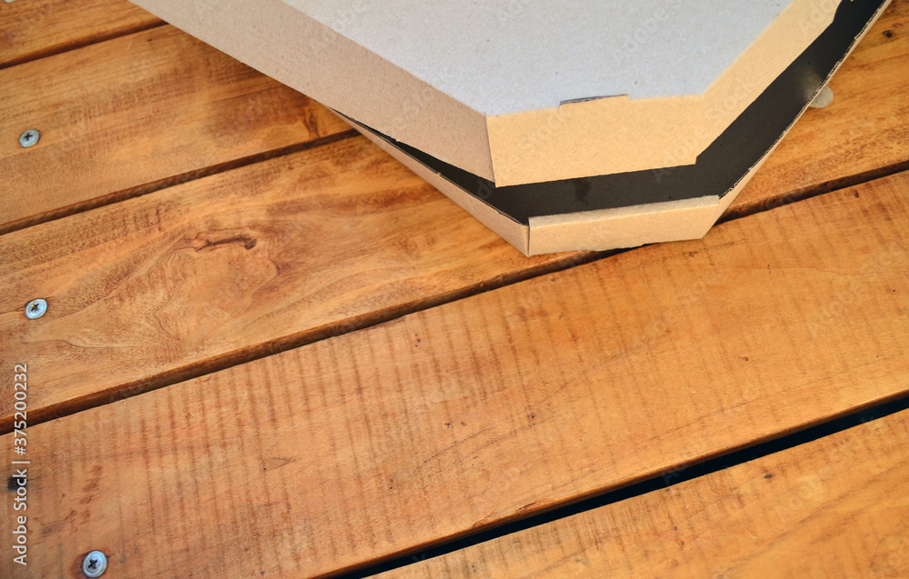 Pizza box on a wooden background. Pizza box on a wooden background.