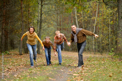 Family of four having fun in autumn forest