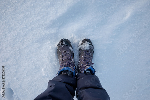 Winter boots with snow grips on snow floor in winter