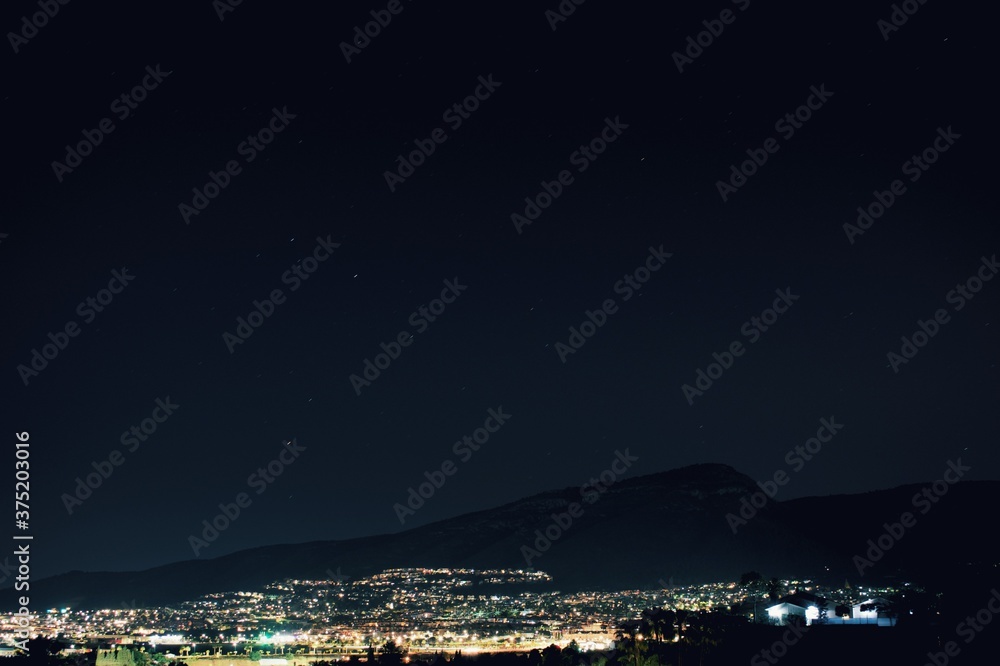 Ciudad nocturna junto a la montaña y luces Ciudad nocturna junto a la montaña y luces