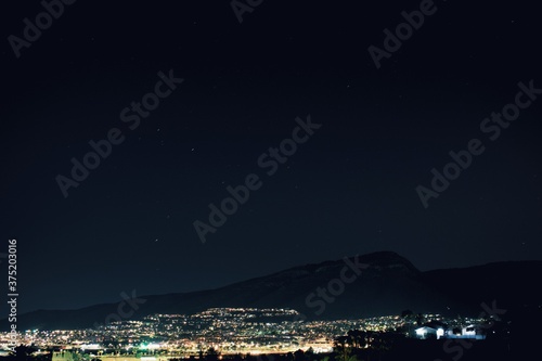 Ciudad nocturna junto a la montaña y luces