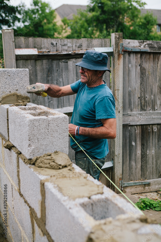 Builder working on a construction site building a wall Builder working on a construction site building a wall