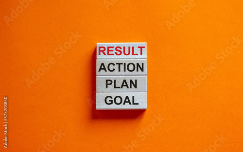 Wooden blocks form the words 'goal, plan, action, result' on beautiful orange background. Business concept. Copy space.