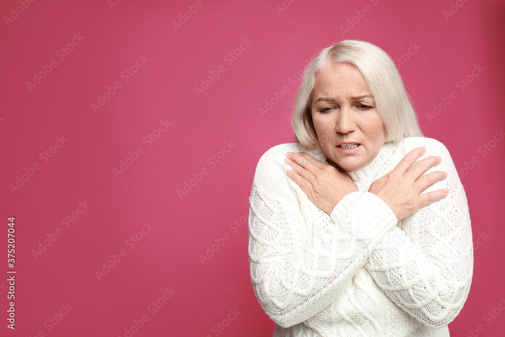 Mature woman suffering from fever on pink background, space for text. Cold symptoms Mature woman suffering from fever on pink background, space for text. Cold symptoms