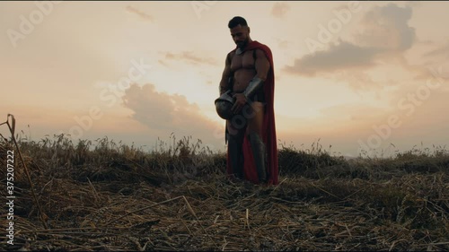Shirtless spartan pretending urinating in helmet in.