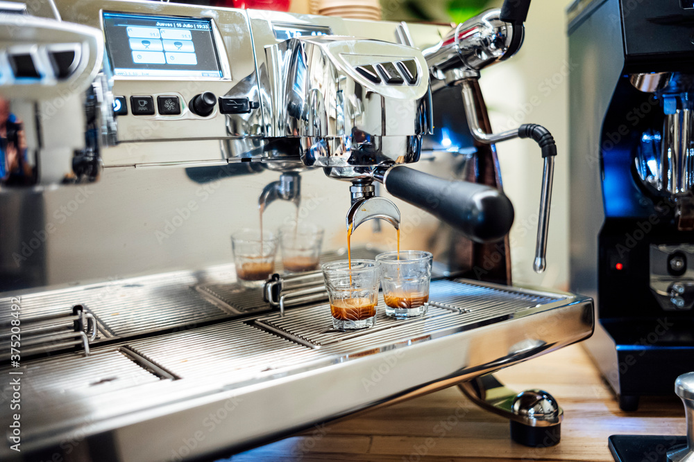 Coffee machine brewing fresh espresso into glass