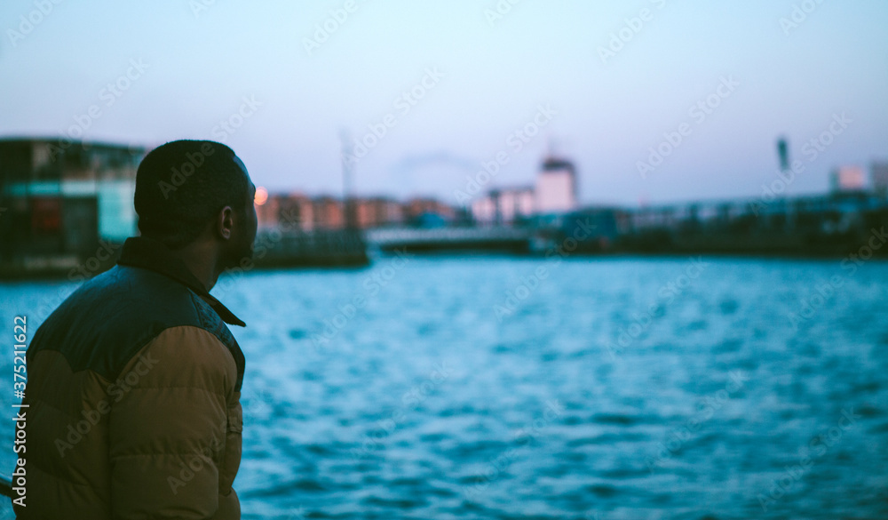 Young man looking across The Thames London Young man looking across The Thames London