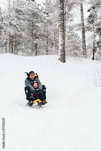 Father and Son Riding Sled Down Hill photo