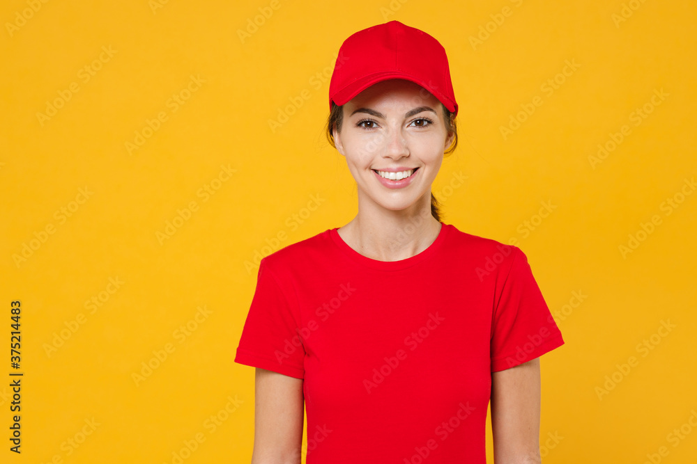 Delivery employee woman in red cap blank t-shirt uniform workwear work courier in service during quarantine coronavirus covid-19 virus, posing look camera isolated on yellow background studio portrait Delivery employee woman in red cap blank t-shirt uniform workwear work courier in service during quarantine coronavirus covid-19 virus, posing look camera isolated on yellow background studio portrait