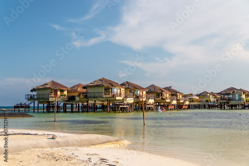 Water Villas (Bungalows) and wooden bridge at Tropical beach in the Caribbean sea