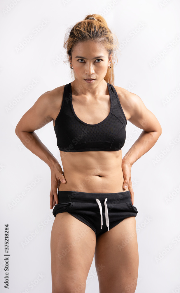 Portrait of sport woman with muscular body, posing against white  background. Asian female showing some strong abs and flat belly six pack.  Stock 写真