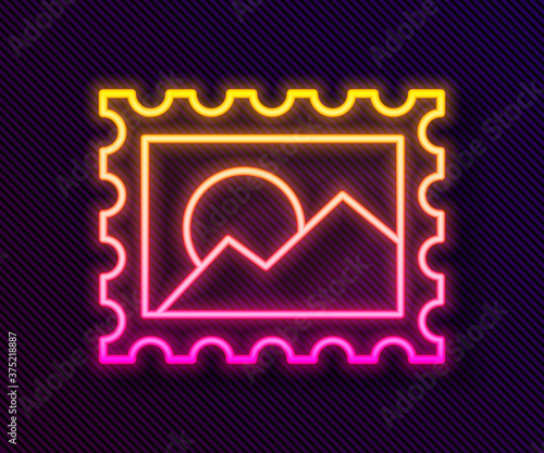 Glowing neon line Postal stamp icon isolated on black background. Vector Illustration.