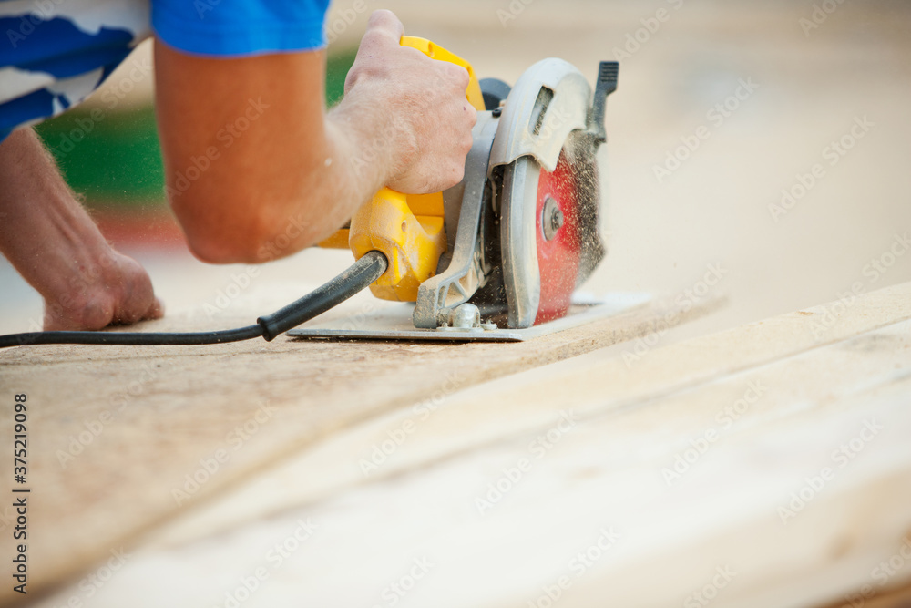 Construction: Carpenter Cutting Panel with Saw Construction: Carpenter Cutting Panel with Saw
