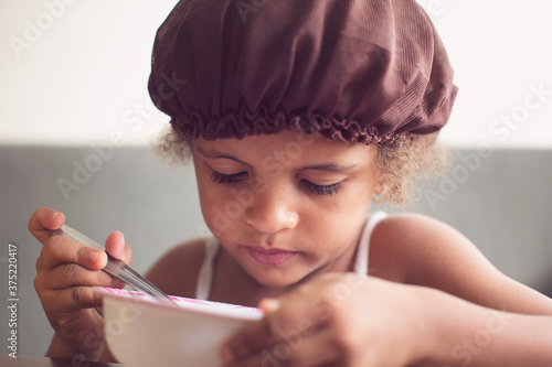 Portrait of a young girl having a bowl of cereal for breakfast