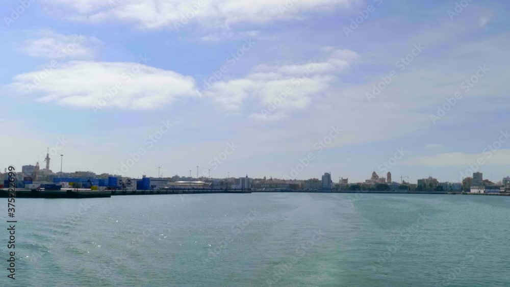 Promenade and the port of Cádiz seen from the ferry, sailing to Puerto de Santa María on a sunny day. Promenade and the port of Cádiz seen from the ferry, sailing to Puerto de Santa María on a sunny day.