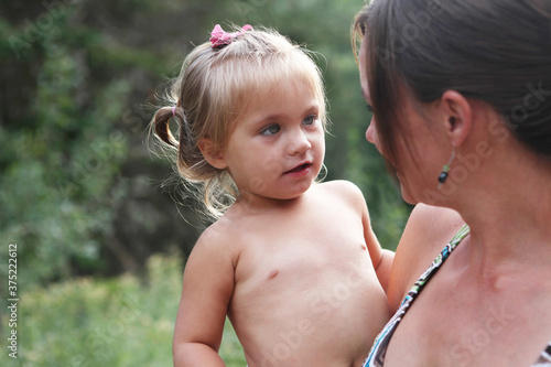 Mother holding toddler while communicating with each other photo