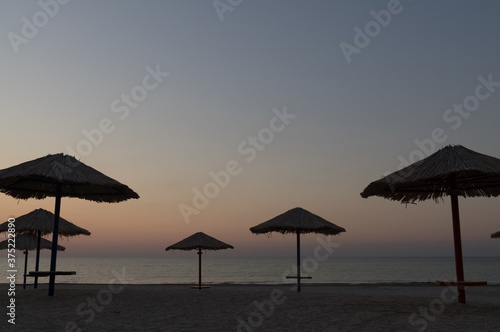 Beautiful seascape with beach umbrellas. Dawn at sea. Image