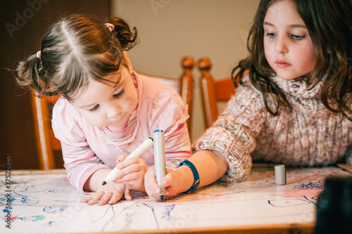 Two little girls colouring in together