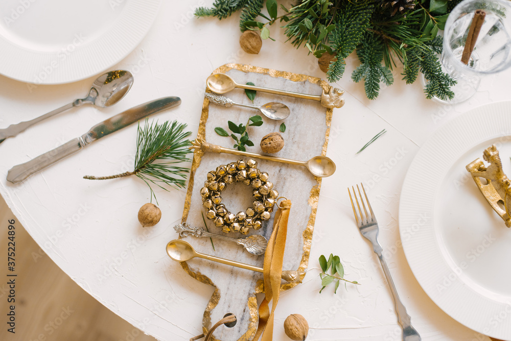 Glass cutting Board with a Christmas wreath on it, walnuts and Cutlery in the Christmas table setting Glass cutting Board with a Christmas wreath on it, walnuts and Cutlery in the Christmas table setting
