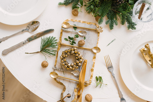 Glass cutting Board with a Christmas wreath on it, walnuts and Cutlery in the Christmas table setting