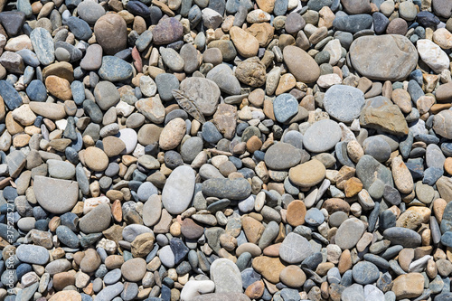 Pebble background smooth stones of various sizes in gray, brown and orange shades.