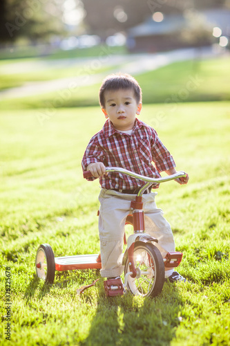 Asian kid riding a tricyle outdoor photo