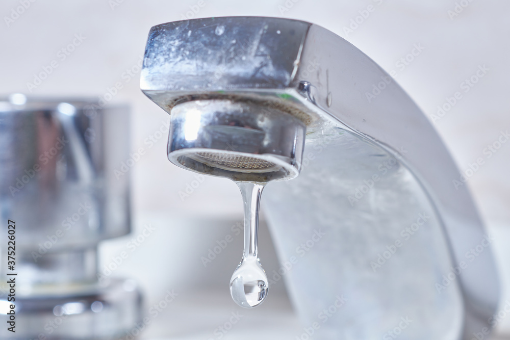 Water tap leaking water drops .Drops and faucet isolated on a white background Water tap leaking water drops .Drops and faucet isolated on a white background