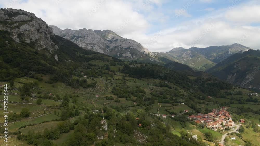 Drone pushes forward valley town surrounded by mountains trees grass Drone pushes forward valley town surrounded by mountains trees grass