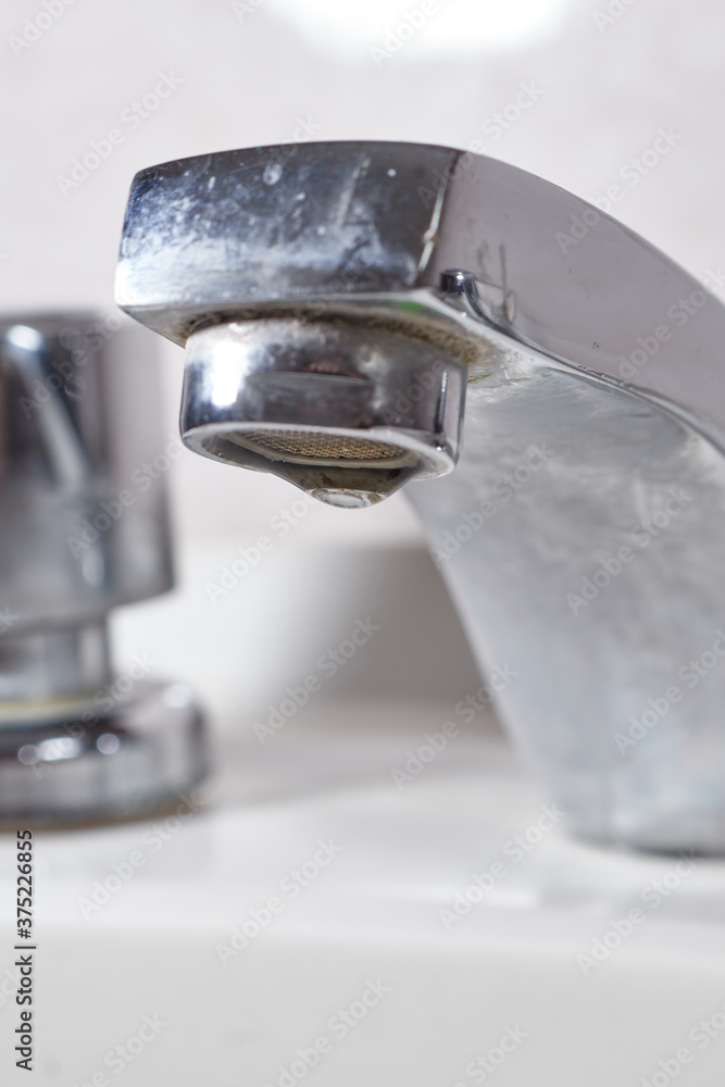 Water tap leaking water drops .Drops and faucet isolated on a white background Water tap leaking water drops .Drops and faucet isolated on a white background