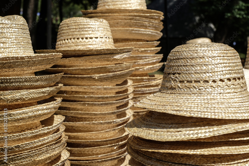 pile of straw hats on table