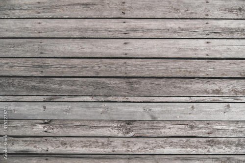Old unpainted wooden planks as horizontal background, wooden floor with cracks and nails