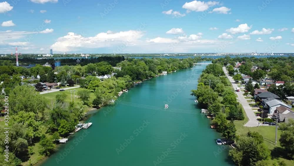Aerial flyover Welland creek in Canada near Niagara Falls during beautiful sunny day with moving boats and clouds in background. Aerial flyover Welland creek in Canada near Niagara Falls during beautiful sunny day with moving boats and clouds in background.