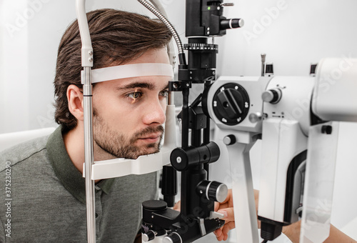 Photos Adult man getting an eye exam at ophthalmology clinic