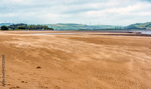 Sand blowing across the beach at the village of Llansteffan, Wales in the summertime