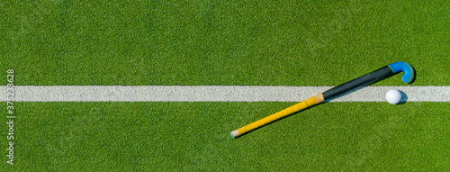 Фотография Field hockey stick and ball on green grass