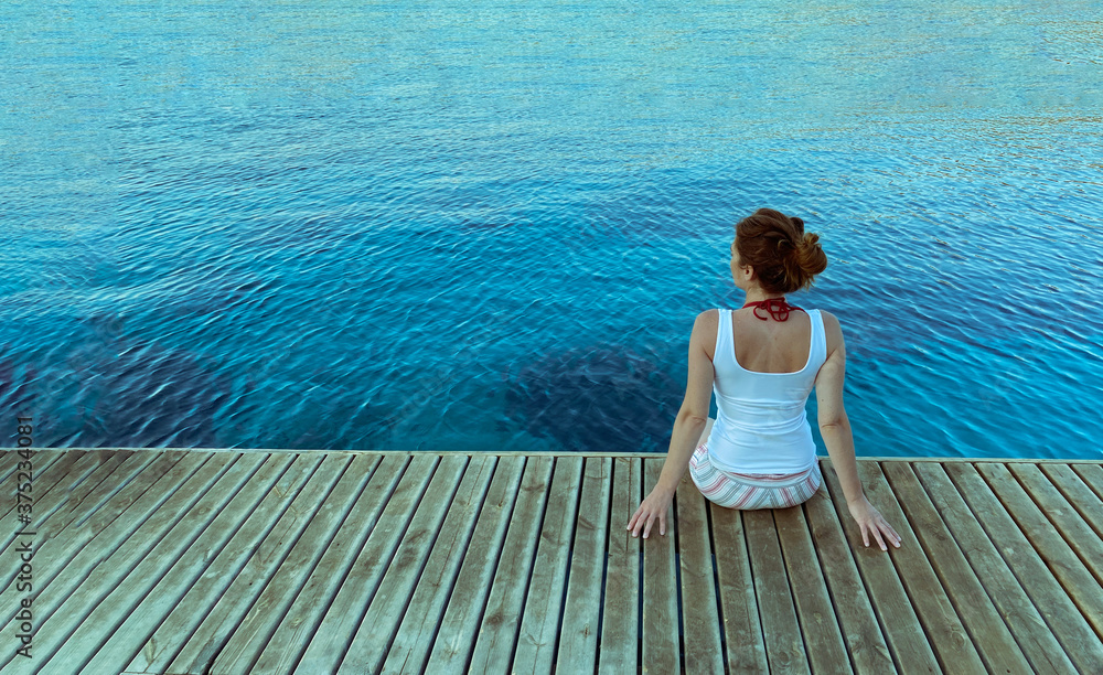woman sitting wooden floor on the sea