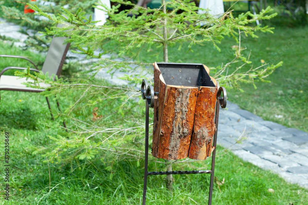 Fototapeta premium One brown old rusty iron urn stands in the park.