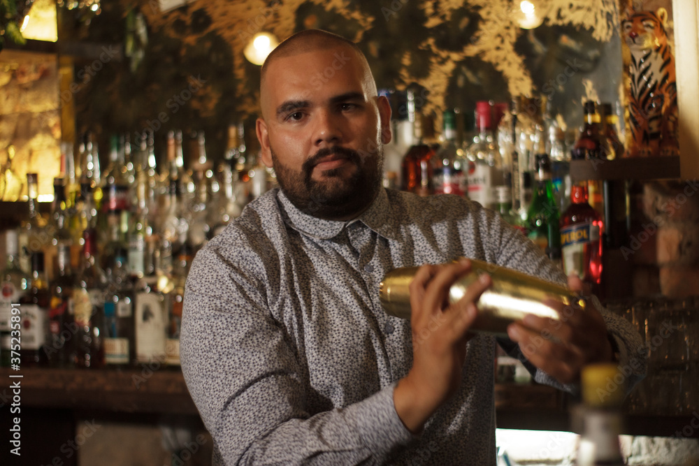 Primer plano de Barman Cantinero mexicano profesional preparando un cóctel alcohólico para los clientes en el bar o discoteca