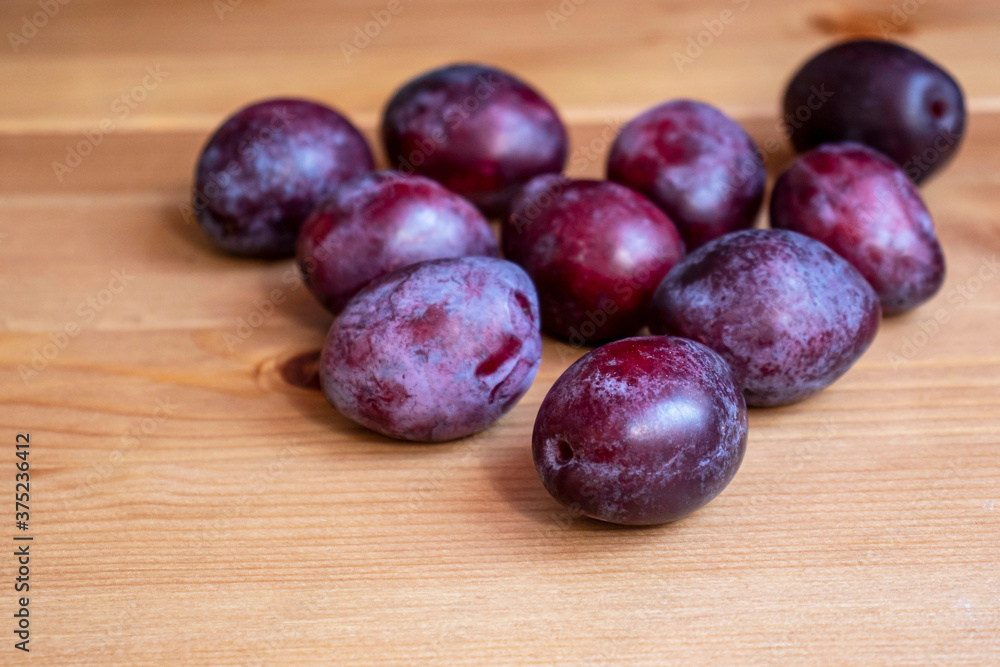 Purple plums on a wooden table Purple plums on a wooden table