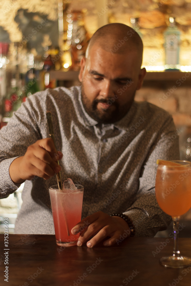 Joven mexicano barman cantinero preparando cocktail en bar discoteca Joven mexicano barman cantinero preparando cocktail en bar discoteca