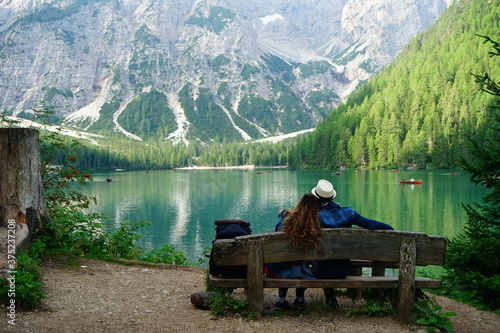 Lovely couple sitting on a bench watching Lago di Braies, Val Pusteria, Dolomiti, Unesco, Trentino Alto Adige, Sudtirol, Italy