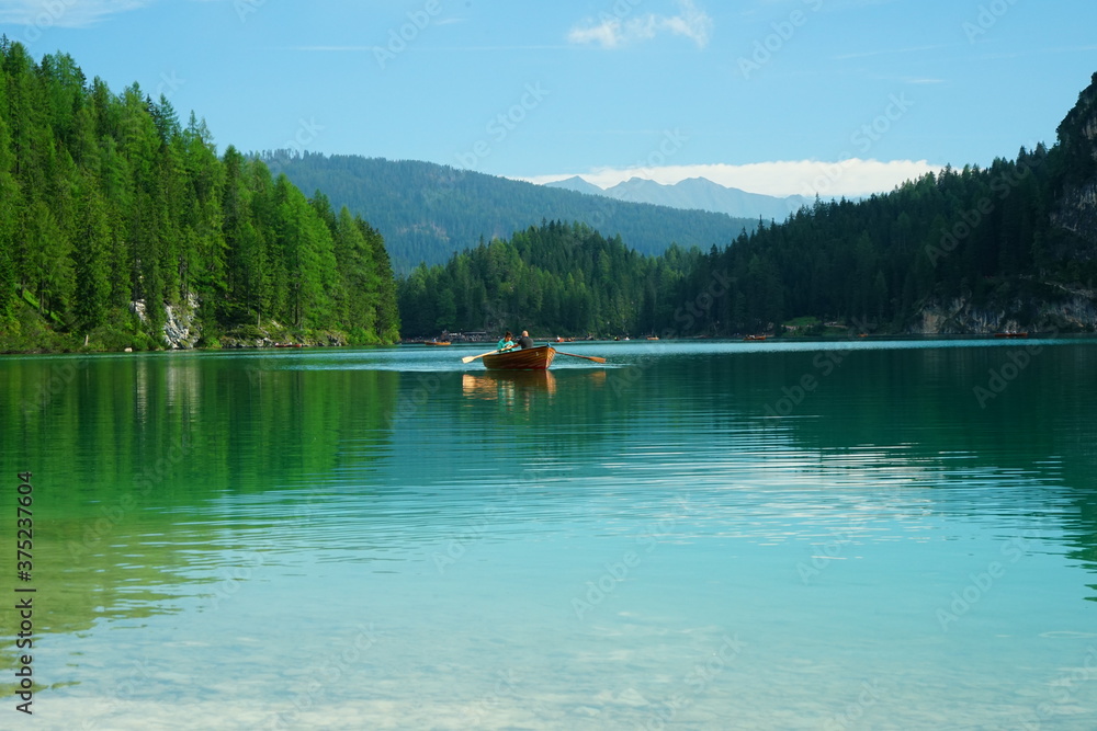 Boat approaching on Braies Lake on a summer day, Sudtirol, Trentino Alto Adige, Italy