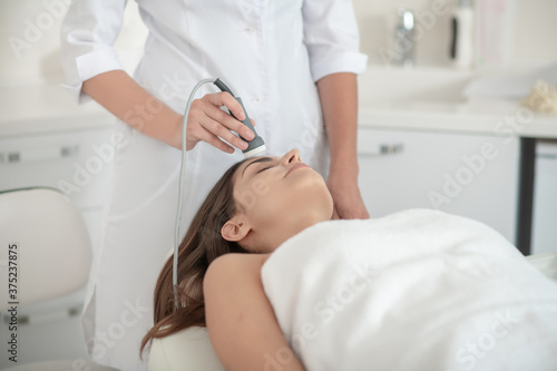 Cosmetologist working with a female customer in a beauty salon