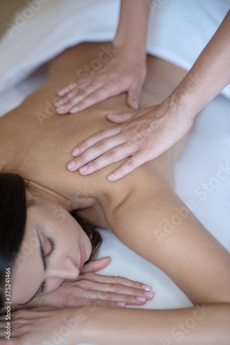 Young woman having back massage and feeling relaxed