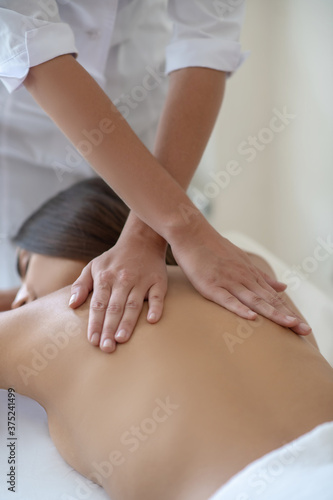 Young woman lying down and having back massage