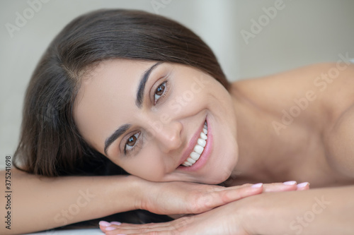 Young woman lying down on a couch and smiling nicely